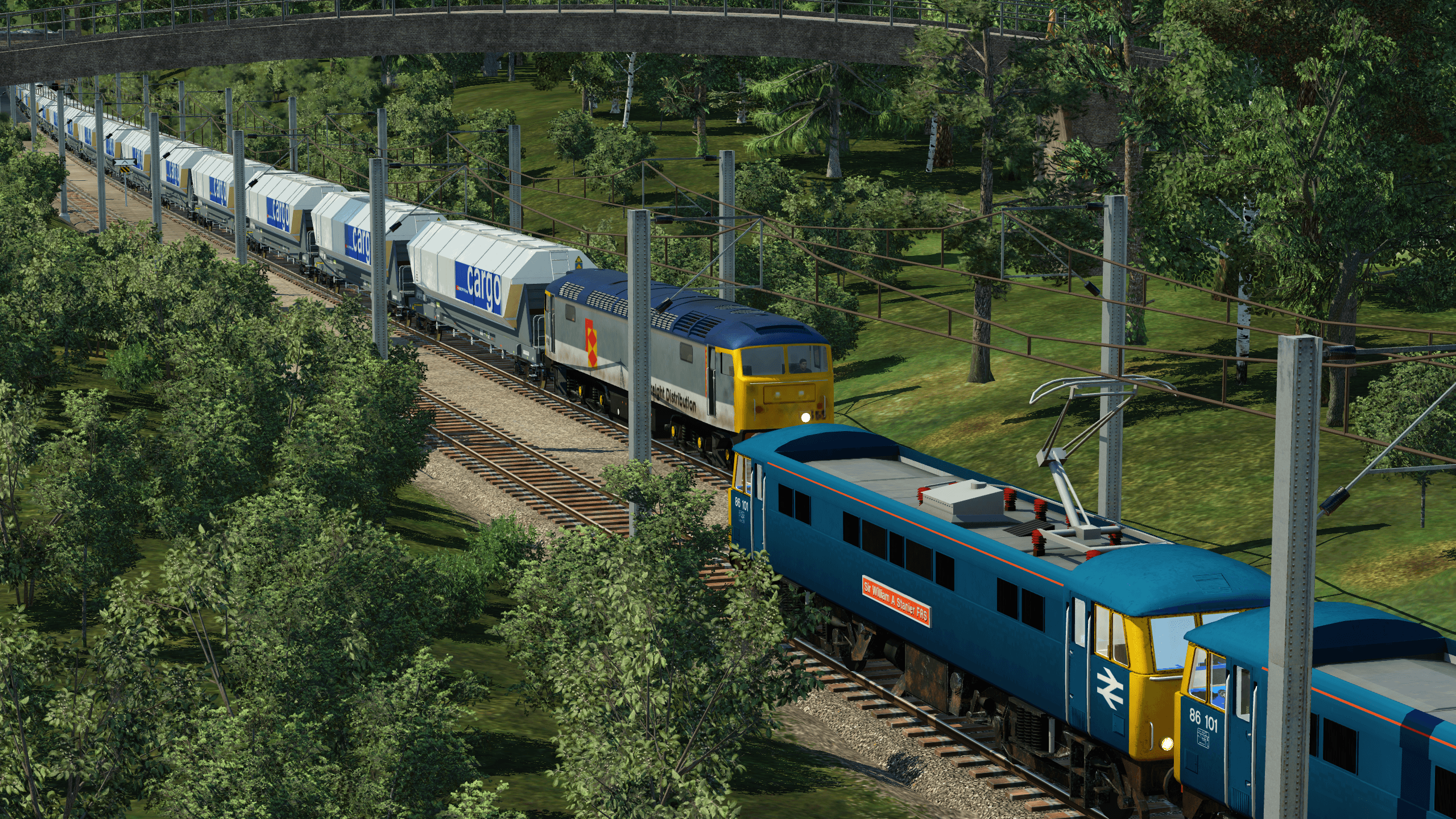 A passenger train from Bradford passes a biomass train on the Leeds-Manchester electrified route.