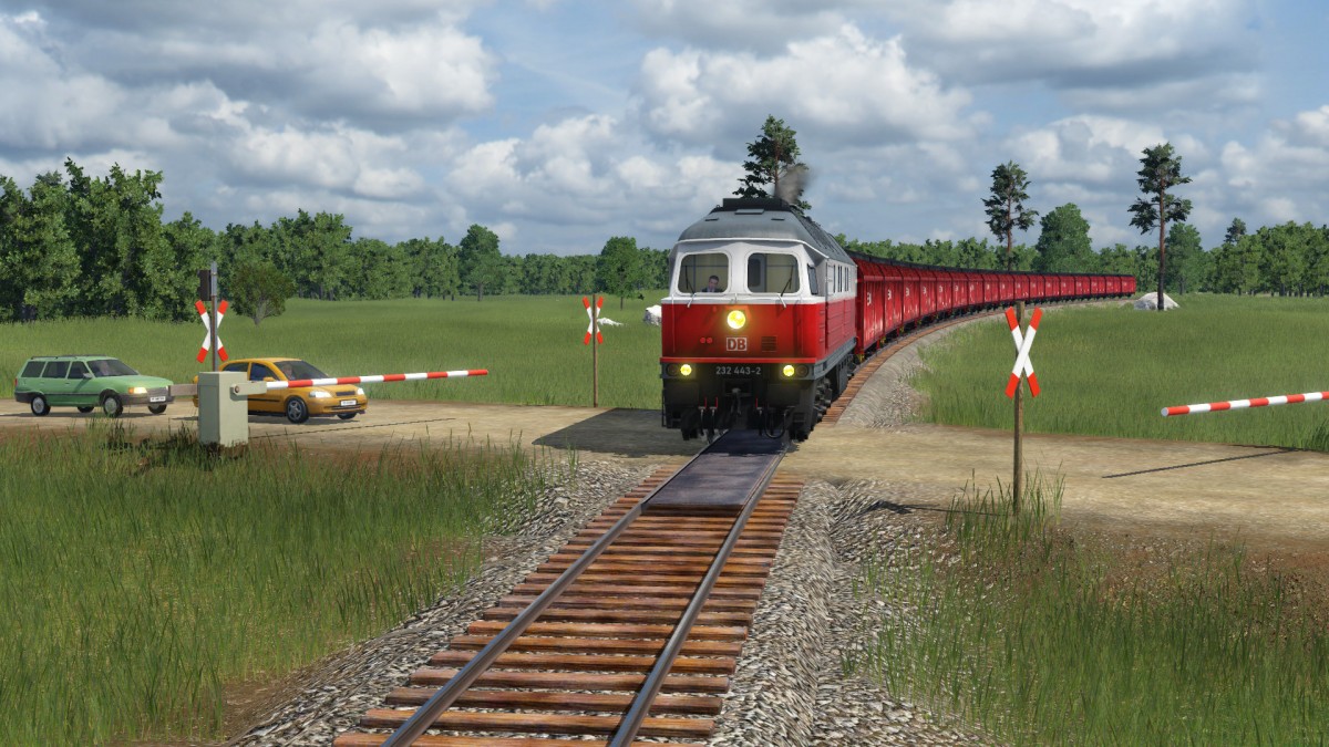 Szene an einem Bahnübergang Teil 2: 232 443-2 mit einem Güterzug am Haken