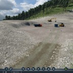 Tipper trucks waiting to be loaded with material near the top of the slide.